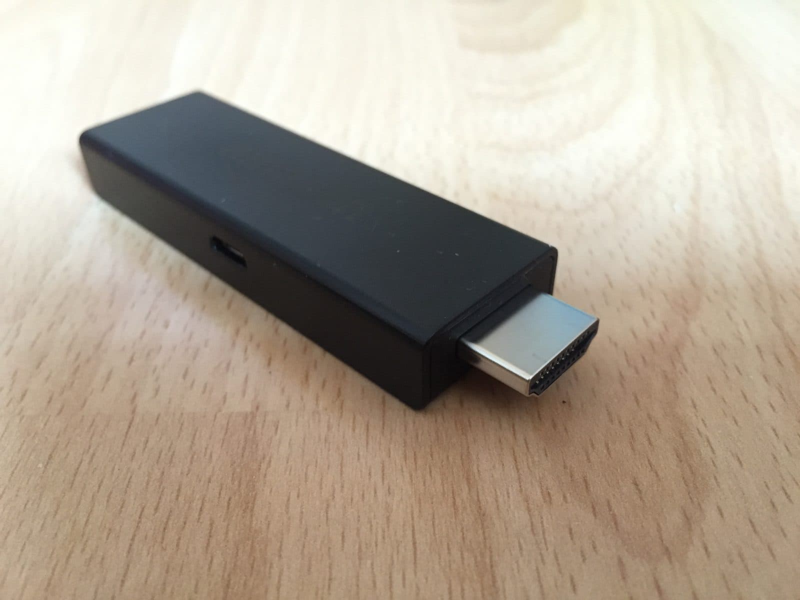 An Amazon Fire TV Stick with its HDMI connector on a wooden table